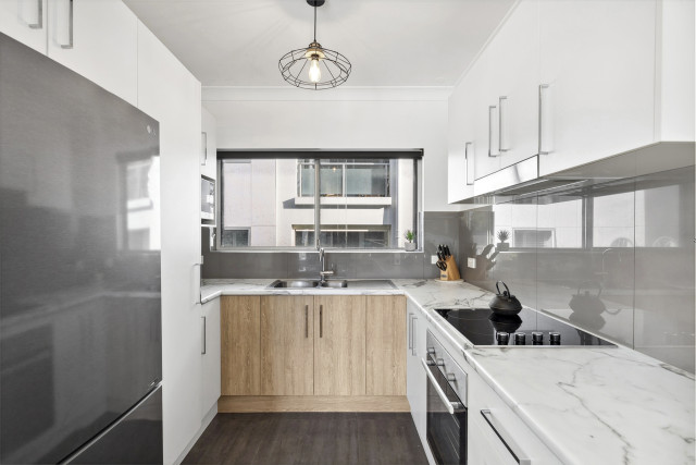The Ocean Echoes kitchen features a modern layout with an oven, cooktop, fridge/freezer, microwave, kettle, toaster and a Nespresso coffee machine — everything guests need for a comfortable stay.